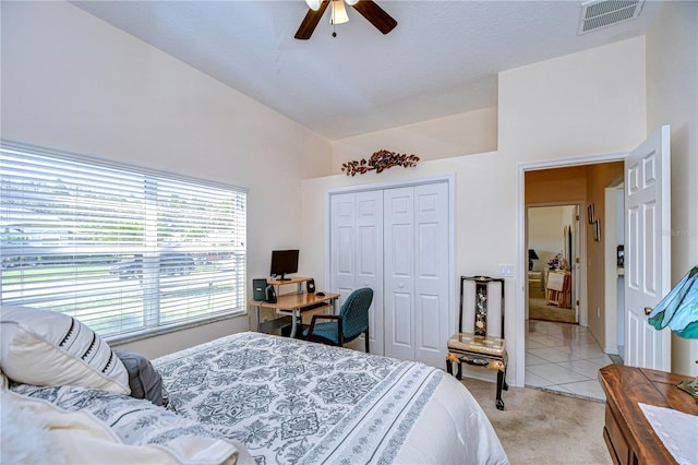 bedroom with a closet, ceiling fan, and light colored carpet