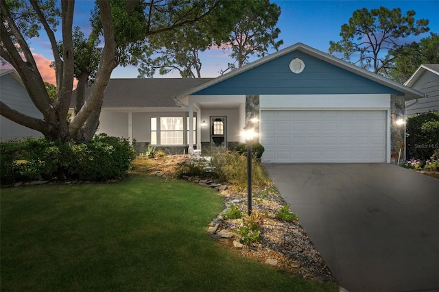 single story home with a garage and a lawn