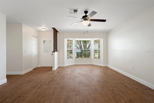 unfurnished living room with ceiling fan and dark hardwood / wood-style flooring