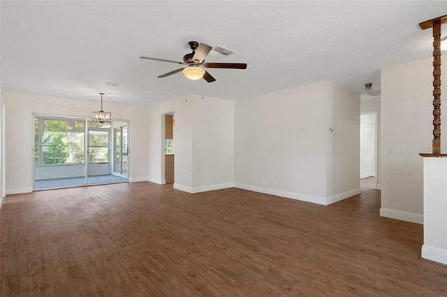 unfurnished living room featuring ceiling fan with notable chandelier and dark hardwood / wood-style floors