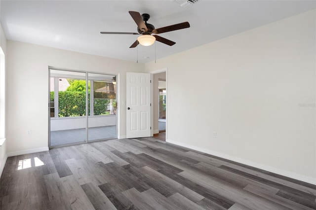 spare room with dark wood-type flooring and ceiling fan