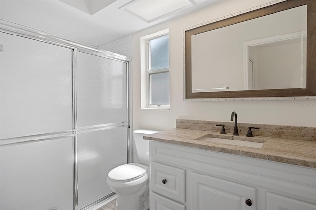 bathroom featuring vanity, toilet, and an enclosed shower