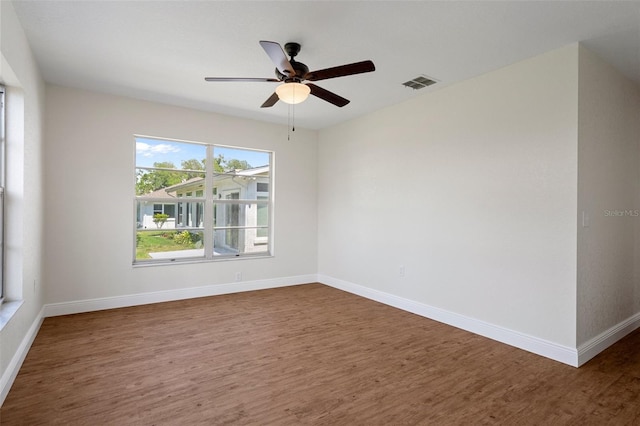 spare room with dark wood-type flooring and ceiling fan