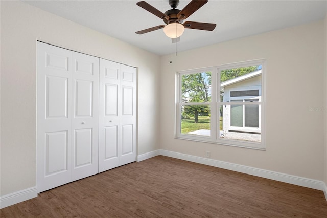 unfurnished bedroom with a closet, ceiling fan, and dark hardwood / wood-style floors