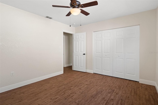 unfurnished bedroom featuring a closet, dark hardwood / wood-style floors, and ceiling fan