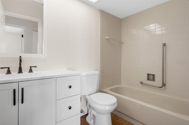 full bathroom featuring vanity, tiled shower / bath combo, hardwood / wood-style flooring, and toilet