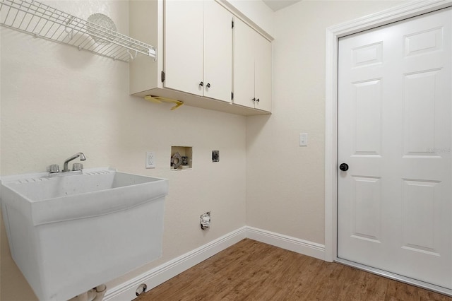 washroom featuring hookup for an electric dryer, wood-type flooring, washer hookup, and cabinets