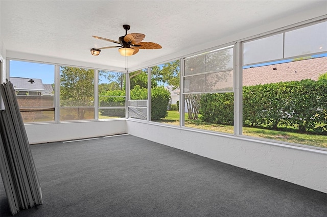 unfurnished sunroom with ceiling fan