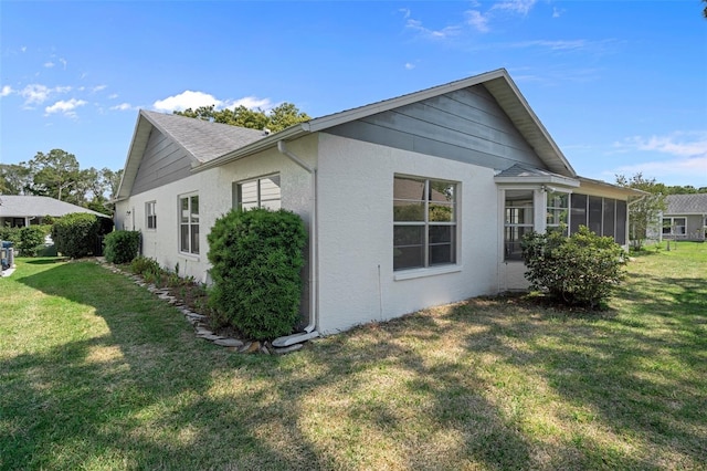 view of property exterior featuring a yard and a sunroom