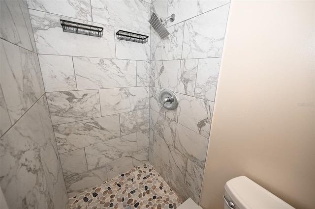 bathroom featuring a tile shower and toilet