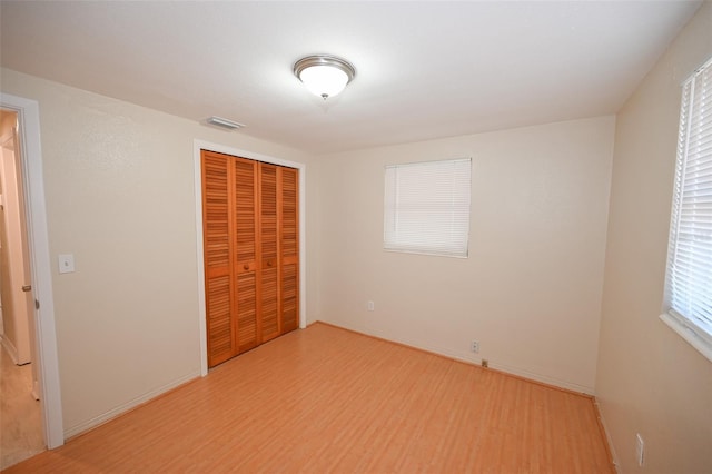 unfurnished bedroom featuring a closet and light wood-type flooring