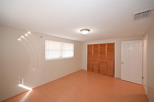 unfurnished bedroom featuring a closet and light hardwood / wood-style floors