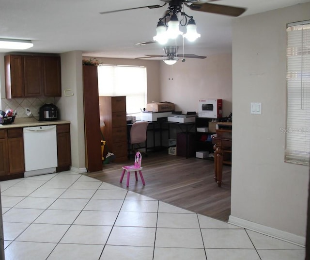 kitchen with light hardwood / wood-style floors, white dishwasher, backsplash, and ceiling fan