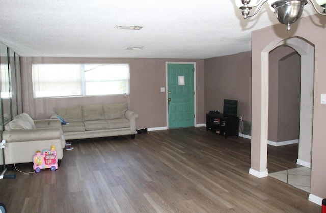 7204 Westcott Dr, Port Richey, FL 34668 - living room with arched walkways, wood finished floors, baseboards, and a chandelier