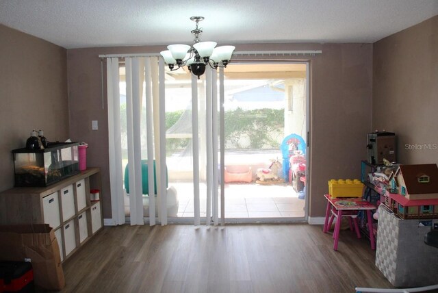 7204 Westcott Dr, Port Richey, FL 34668 - rec room with wood finished floors and a chandelier