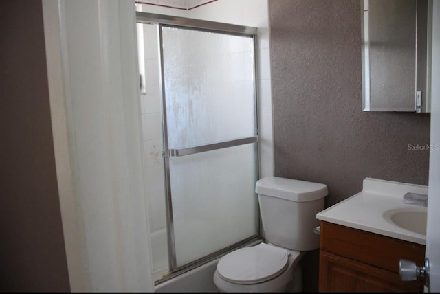 full bathroom with vanity, shower / bath combination with glass door, and toilet