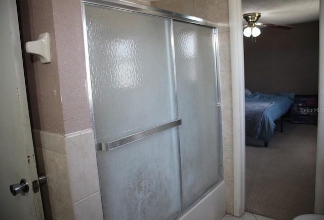 bathroom with ceiling fan and bath / shower combo with glass door