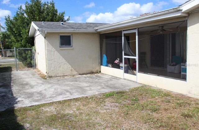 7204 Westcott Dr, Port Richey, FL 34668 - rear view of property featuring a sunroom, stucco siding, a patio area, and fence