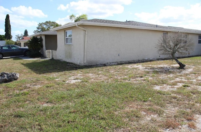 7204 Westcott Dr, Port Richey, FL 34668 - view of side of home with stucco siding and a yard