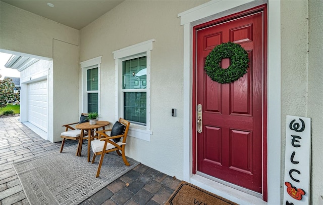 entrance to property with covered porch and a garage