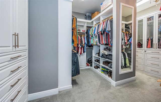 walk in closet featuring light carpet