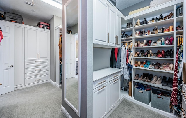 walk in closet with light colored carpet