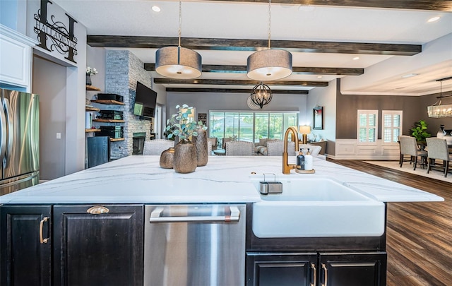 kitchen featuring a healthy amount of sunlight, appliances with stainless steel finishes, dark hardwood / wood-style flooring, and hanging light fixtures