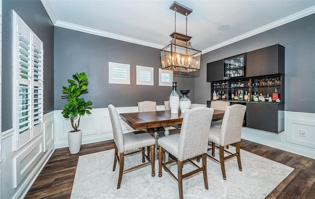 dining space featuring crown molding, an inviting chandelier, and dark hardwood / wood-style flooring