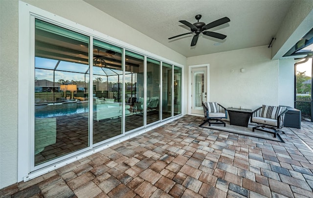 view of patio / terrace featuring ceiling fan and glass enclosure