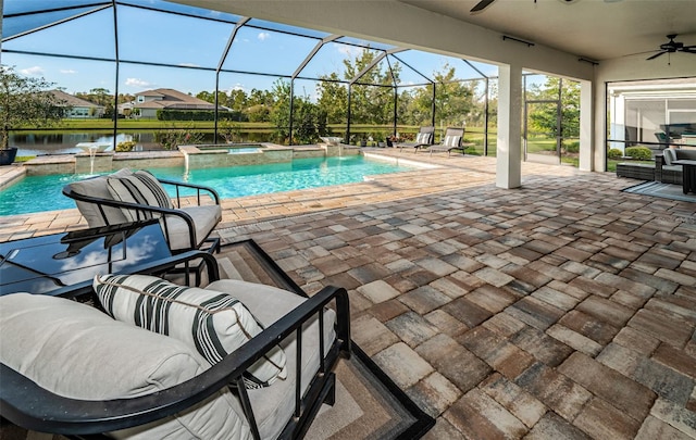 view of pool with ceiling fan, glass enclosure, a patio, an in ground hot tub, and a water view