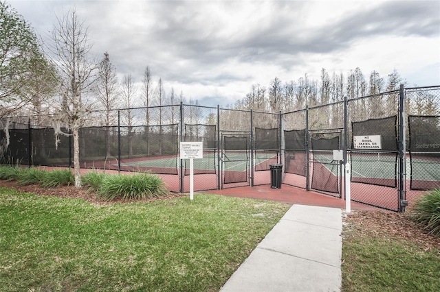 view of tennis court featuring a yard