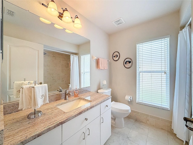 bathroom with tile patterned flooring, vanity, toilet, and walk in shower