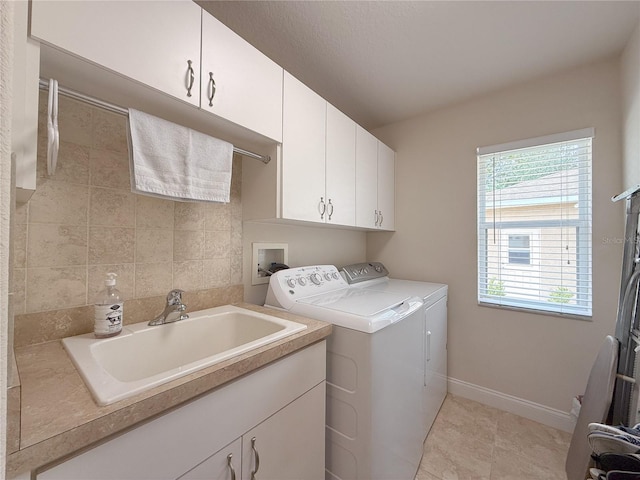 washroom with washing machine and clothes dryer, sink, light tile patterned flooring, and cabinets