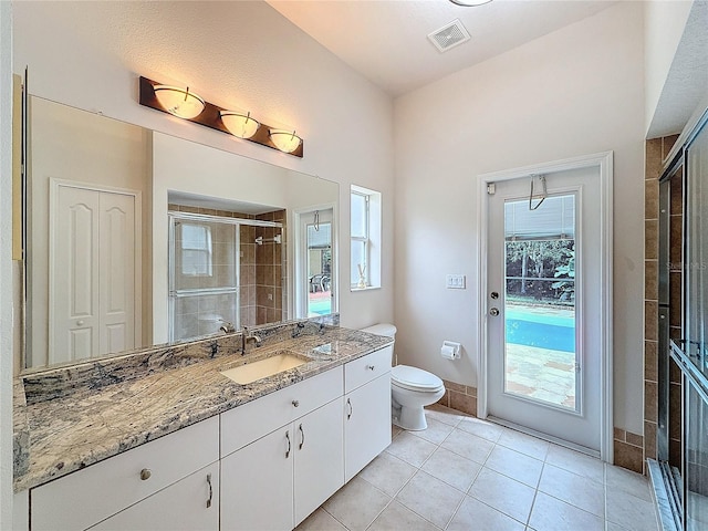 bathroom with tile patterned floors, vanity, an enclosed shower, and toilet