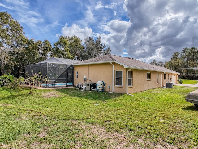 back of house with a pool, a lawn, a lanai, and central air condition unit