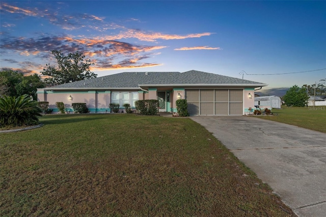 ranch-style house with a garage and a lawn