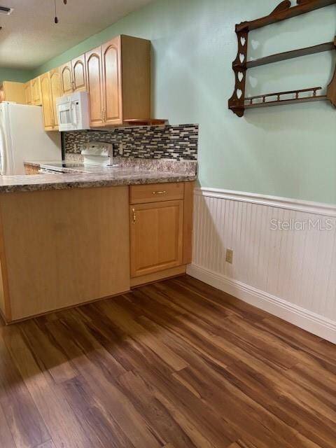 kitchen featuring decorative backsplash, dark hardwood / wood-style floors, light brown cabinetry, and white appliances