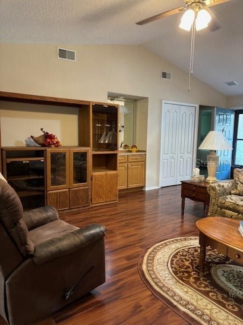 living room featuring ceiling fan, a textured ceiling, vaulted ceiling, and dark hardwood / wood-style flooring