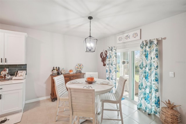 tiled dining room featuring an inviting chandelier