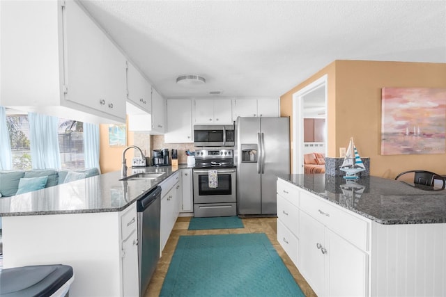 kitchen featuring white cabinetry, stainless steel appliances, tasteful backsplash, and sink