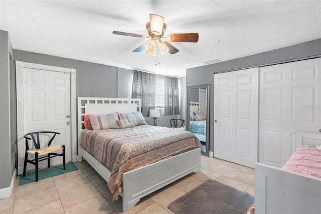 bedroom with a closet, ceiling fan, and light tile patterned floors