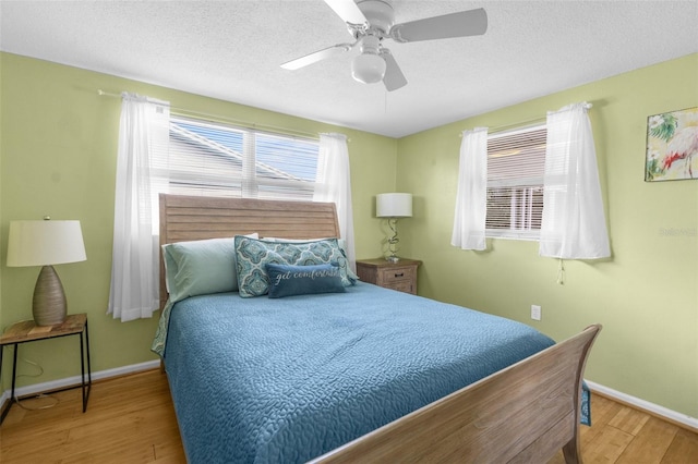 bedroom featuring ceiling fan, a textured ceiling, and hardwood / wood-style floors