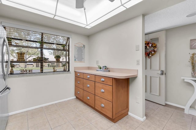 interior space featuring stainless steel fridge and light tile patterned floors