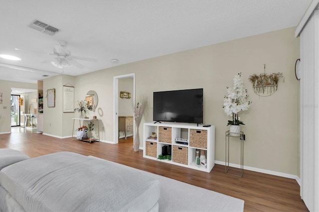 living room with ceiling fan and wood-type flooring