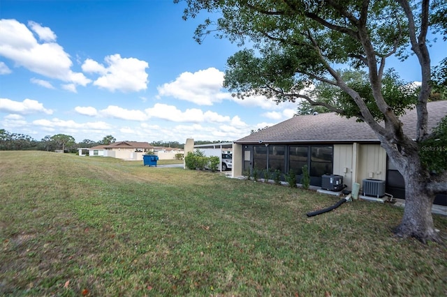 view of yard featuring central AC unit and a sunroom