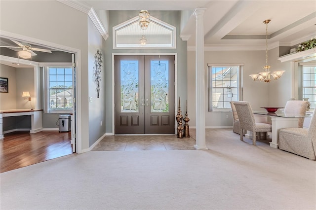 entryway with light hardwood / wood-style floors, crown molding, decorative columns, and plenty of natural light