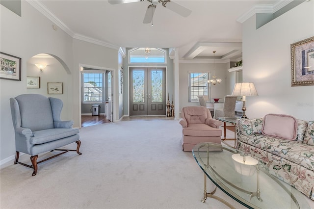 living room with crown molding, light carpet, and ceiling fan with notable chandelier