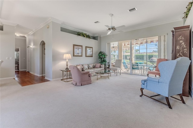 living room featuring ornamental molding, light wood-type flooring, and ceiling fan