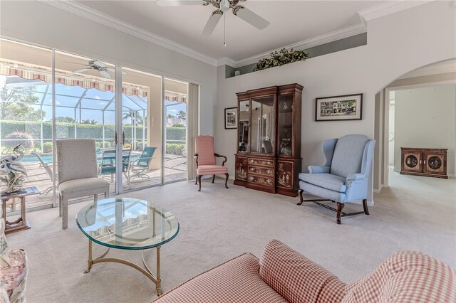 living area featuring ceiling fan, carpet, and ornamental molding