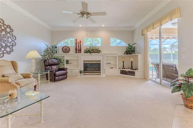 carpeted living room with ornamental molding, a fireplace, and ceiling fan